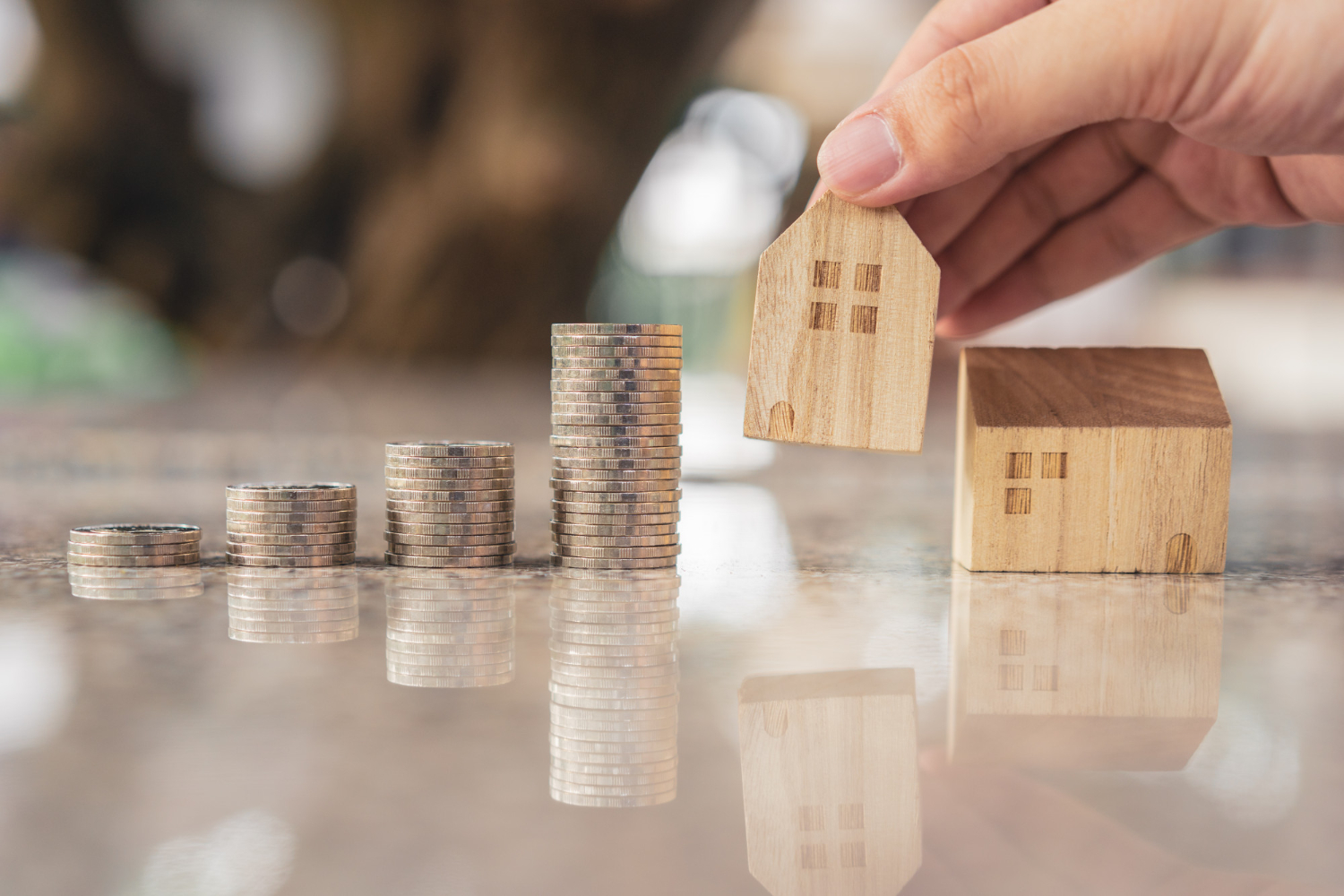 Choisir à la main le mini modèle de maison en bois à partir du modèle et de la rangée de pièces sur la table en bois,