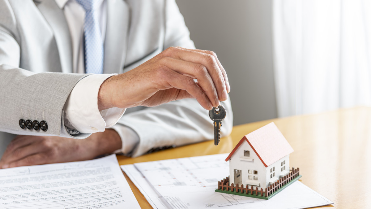 main d'un professionnel de l'immobilier détenant les clés d'une maison